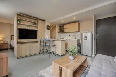 a kitchen and living room with a couch and a table at Apartamentos Oslo Tesoro by HOUSY in Medellín
