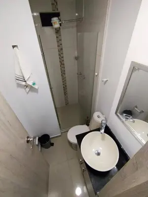 a bathroom with a sink and a toilet and a mirror at Apartaestudio Ofisuite-Medellin in Medellín