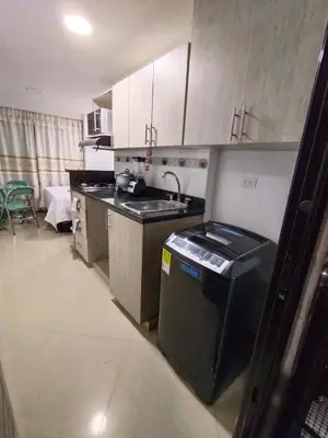 a small kitchen with a sink and a stove at Apartaestudio Ofisuite-Medellin in Medellín