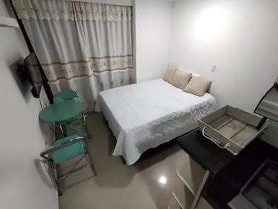 a small bedroom with a bed and a chair at Apartaestudio Ofisuite-Medellin in Medellín