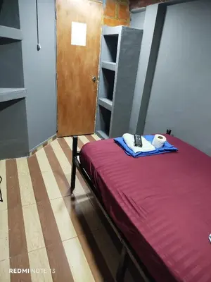 a room with a bed and a wooden door and shelves at Dulce Hogar Aparta Hotel in Medellín