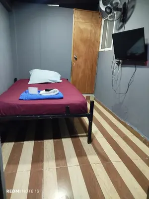 a bedroom with a bed with a red blanket and a flat screen tv at Dulce Hogar Aparta Hotel in Medellín