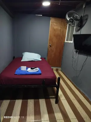 a bedroom with a bed with a red blanket and a fan at Dulce Hogar Aparta Hotel in Medellín