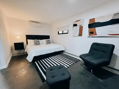 a bedroom with a bed and a pair of chairs at Casa Lujosa vacacional El Poblado Medellín Por día Con Piscina Jacuzzi AC 9br in Estación El Salto