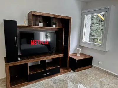 a entertainment center with a television in a living room at Casa Lujosa vacacional El Poblado Medellín Por día Con Piscina Jacuzzi AC 9br in Estación El Salto