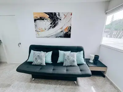 a black couch in a room with a painting on the wall at Casa Lujosa vacacional El Poblado Medellín Por día Con Piscina Jacuzzi AC 9br in Estación El Salto