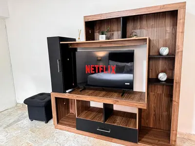 a tv in a wooden entertainment center with a television at Casa Lujosa vacacional El Poblado Medellín Por día Con Piscina Jacuzzi AC 9br in Estación El Salto