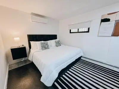a white bedroom with a bed and a television at Casa Lujosa vacacional El Poblado Medellín Por día Con Piscina Jacuzzi AC 9br in Estación El Salto