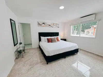 a white bedroom with a bed and a window at Casa Lujosa vacacional El Poblado Medellín Por día Con Piscina Jacuzzi AC 9br in Estación El Salto
