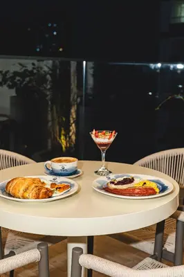 a table with two plates of food and a glass at Hotel Tres Altares Sabaneta in Sabaneta