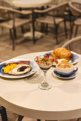 a table with plates of food and a wine glass on it at Hotel Tres Altares Sabaneta in Sabaneta
