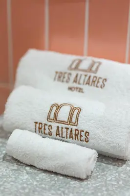 two stacks of white towels on a counter at Hotel Tres Altares Sabaneta in Sabaneta