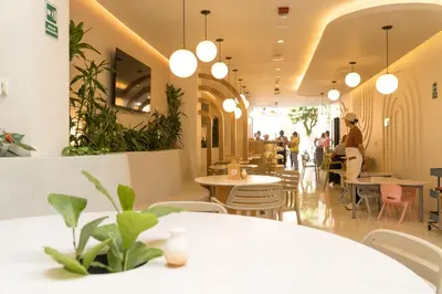 a restaurant with tables and chairs and potted plants at Hotel Tres Altares Sabaneta in Sabaneta