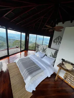 a bedroom with a bed in a room with windows at La mejor vista del eje cafetero en el Chalet La Gitana in Marsella
