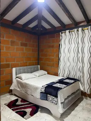 a bed in a room with a brick wall at Aloha Campestre in San Rafael