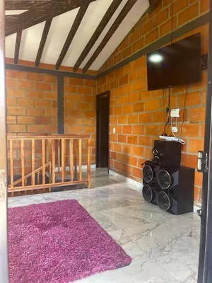 a room with a brick wall with a flat screen tv at Aloha Campestre in San Rafael