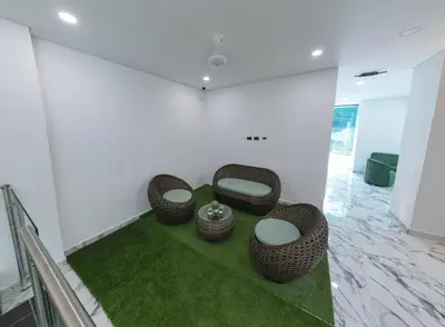 a room with four wicker chairs and green carpet at Hotel La Esmeralda Doradal in Doradal