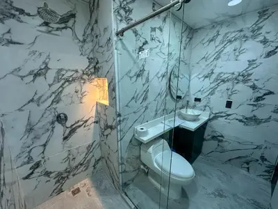 a bathroom with a shower and a toilet and a sink at Hotel La Esmeralda Doradal in Doradal