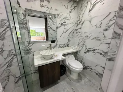 a bathroom with a toilet and a sink and a mirror at Hotel La Esmeralda Doradal in Doradal