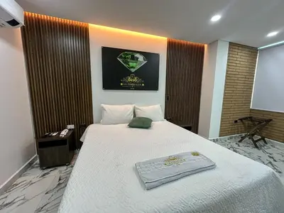 a bedroom with a large white bed in a room at Hotel La Esmeralda Doradal in Doradal
