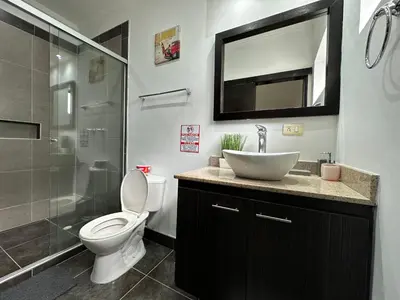 a bathroom with a toilet and a sink and a shower at London suites, By Poblado Suites in Medellín