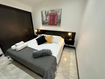 a bedroom with a bed with a red phone booth on the wall at London suites, By Poblado Suites in Medellín