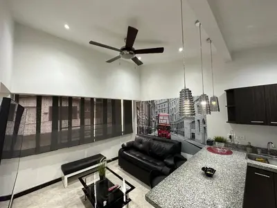 a living room with a couch and a ceiling fan at London suites, By Poblado Suites in Medellín