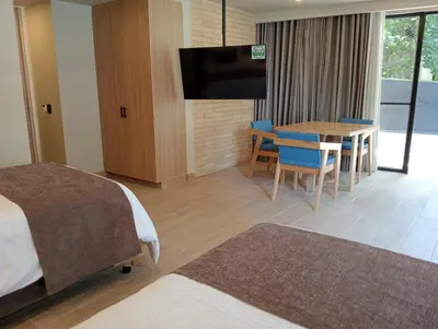 a hotel room with a bed and a table and a tv at Hotel Rulay Medellin in Medellín