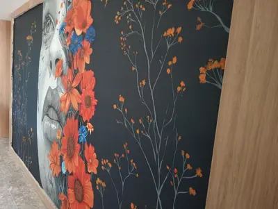 a wall with a painting of a vase with flowers at Hotel Rulay Medellin in Medellín