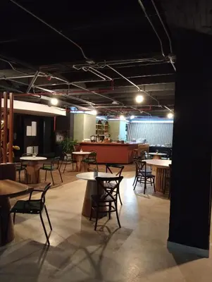 a room with tables and chairs and a cafeteria at Hotel Rulay Medellin in Medellín