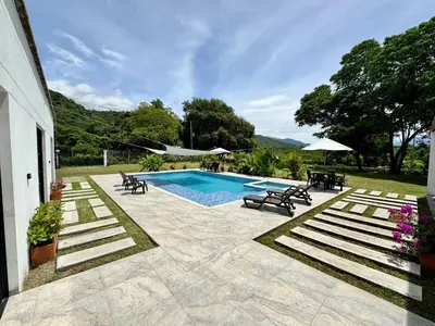 a swimming pool with chairs and a table at La Mágica Finca en Santa Fe de Antioquia in Santa Fe de Antioquia