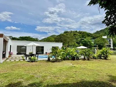 a white house with a pool and a yard at La Mágica Finca en Santa Fe de Antioquia in Santa Fe de Antioquia