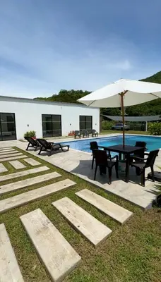 a patio with a table with an umbrella and a pool at La Mágica Finca en Santa Fe de Antioquia in Santa Fe de Antioquia