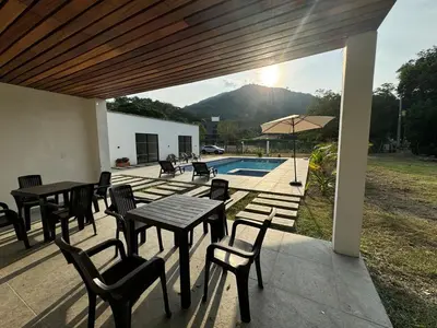 a patio with tables and chairs and a pool at La Mágica Finca en Santa Fe de Antioquia in Santa Fe de Antioquia