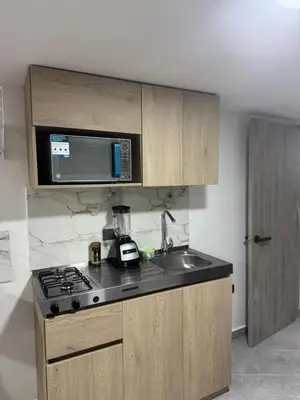 a kitchen with a sink and a microwave at Villa Loreto Aparta estudio 204 in Medellín