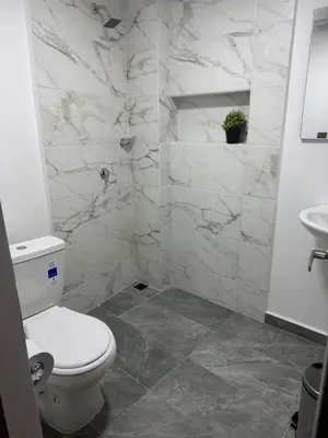 a white bathroom with a toilet and a sink at Villa Loreto Aparta estudio 204 in Medellín