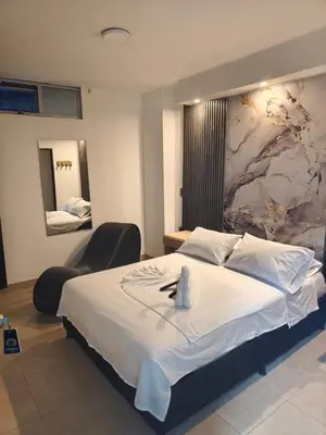 a bedroom with a large bed with a painting on the wall at Hotel Centrica Del Palo 45 in Medellín
