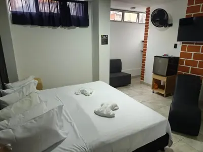 a bedroom with a bed with towels on it at Hotel Centrica Del Palo 45 in Medellín