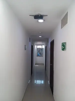 a hallway with white walls and a ceiling at Hotel Centrica Del Palo 45 in Medellín