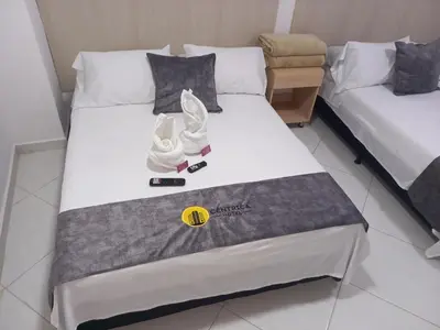 a bed in a hotel room with towels on it at Hotel Centrica Del Palo 45 in Medellín