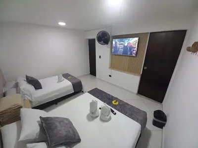 a hotel room with two beds and a tv at Hotel Centrica Del Palo 45 in Medellín