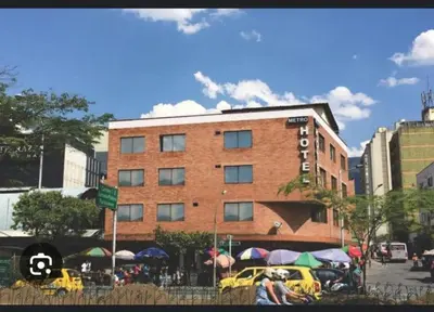 a large brick building with umbrellas in front of it at Hmetrohotel in Medellín