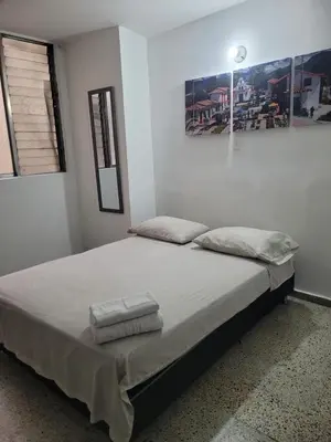 a bed in a room with two towels on it at Hmetrohotel in Medellín