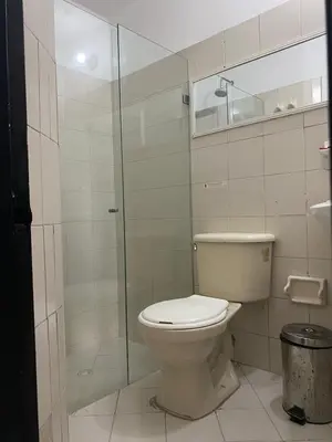 a bathroom with a toilet and a glass shower at Hmetrohotel in Medellín