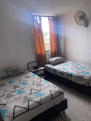 a bedroom with two beds and a window at Hmetrohotel in Medellín