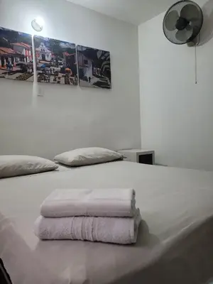 a white bed with two towels on top of it at Hmetrohotel in Medellín