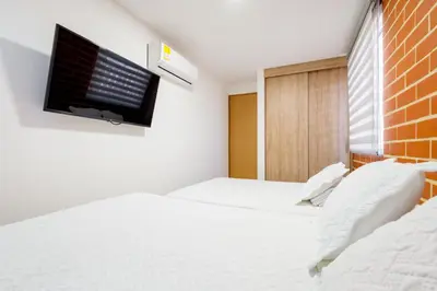 a bedroom with two beds and a tv on the wall at Apartamento San Jerónimo - Antioquia in San Jerónimo