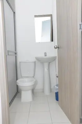 a white bathroom with a toilet and a sink at El ensueño in Manizales