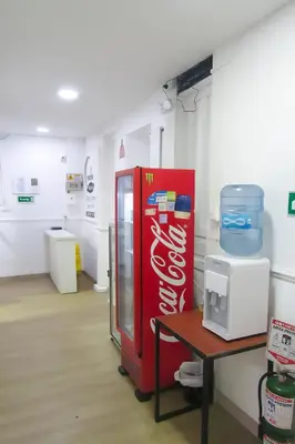 a red coke machine in a room with a table at El ensueño in Manizales