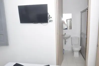 a bathroom with a toilet and a tv on the wall at El ensueño in Manizales